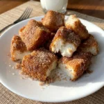 Angel Cake Churro Bites coated in cinnamon sugar on a white plate