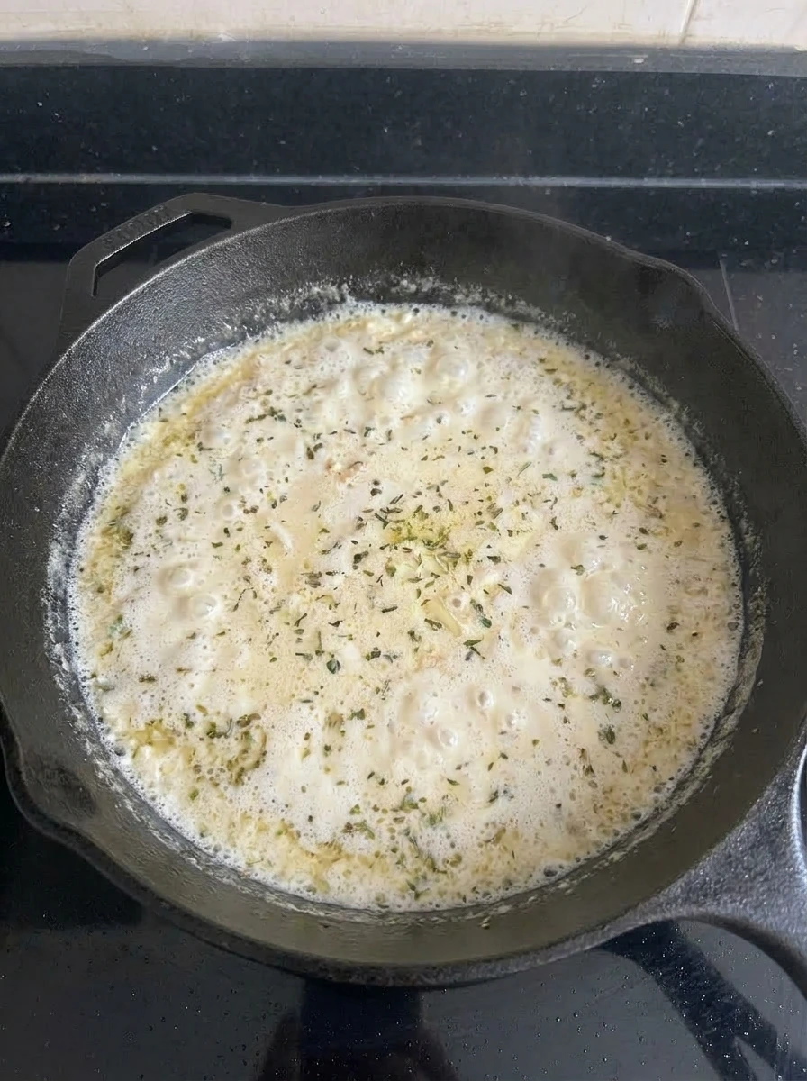 Creamy herb sauce bubbling for Creamy Herb Chicken