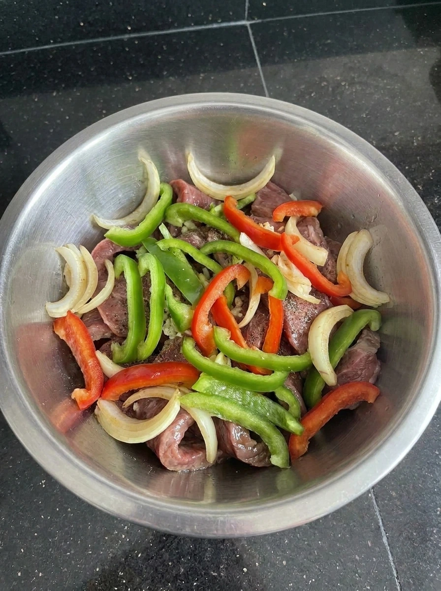 Beef layered with sliced peppers and onions