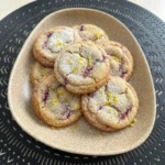 Soft Lemon Raspberry Cookies with powdered sugar and raspberry pieces.