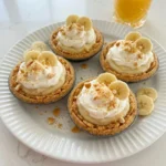 Mini Banana Cream Pies topped with whipped cream and banana slices.