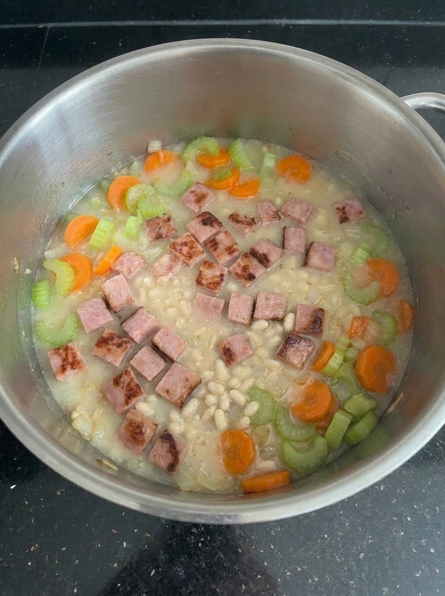 Navy bean soup thickening while simmering.