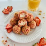 Creamy No Bake Strawberry Crunch Cheesecake Bites coated in strawberry cookie crumbs.