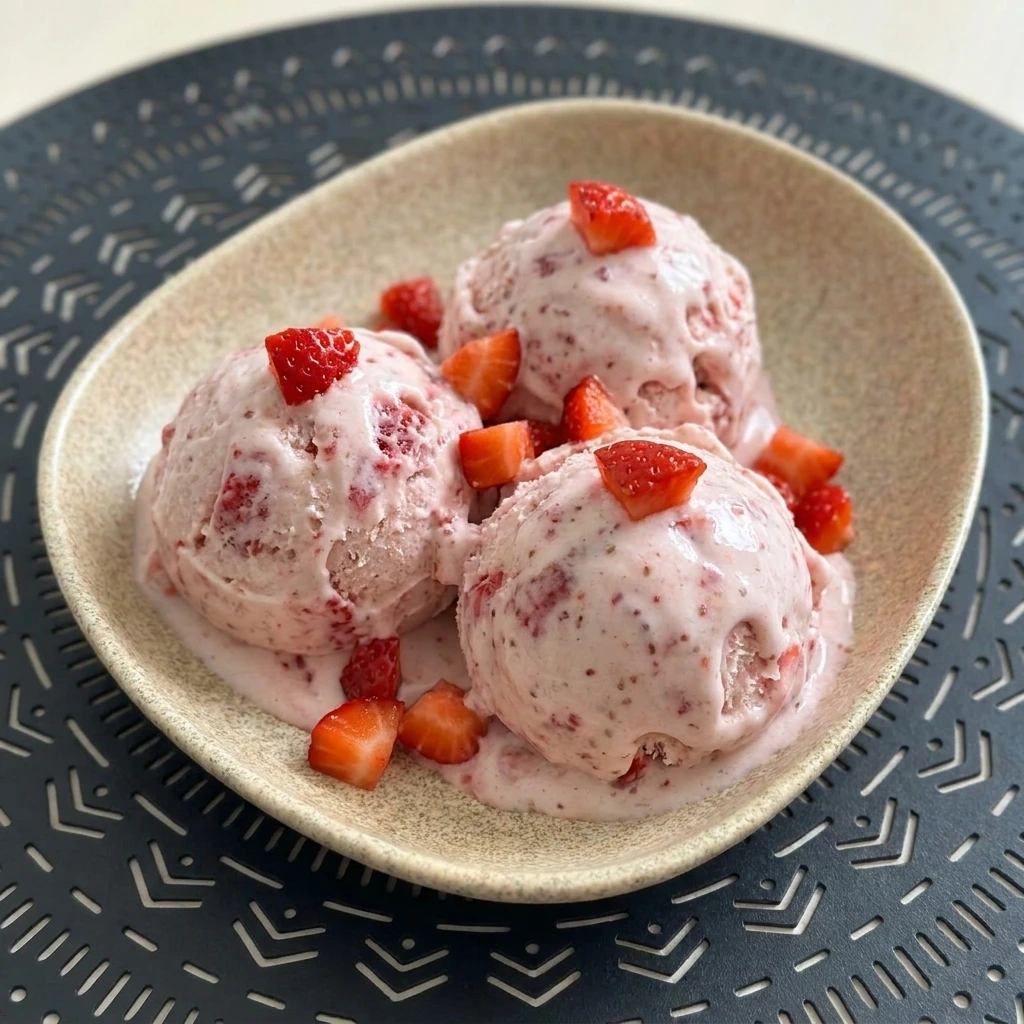 Creamy homemade strawberry ice cream with fresh strawberry pieces.