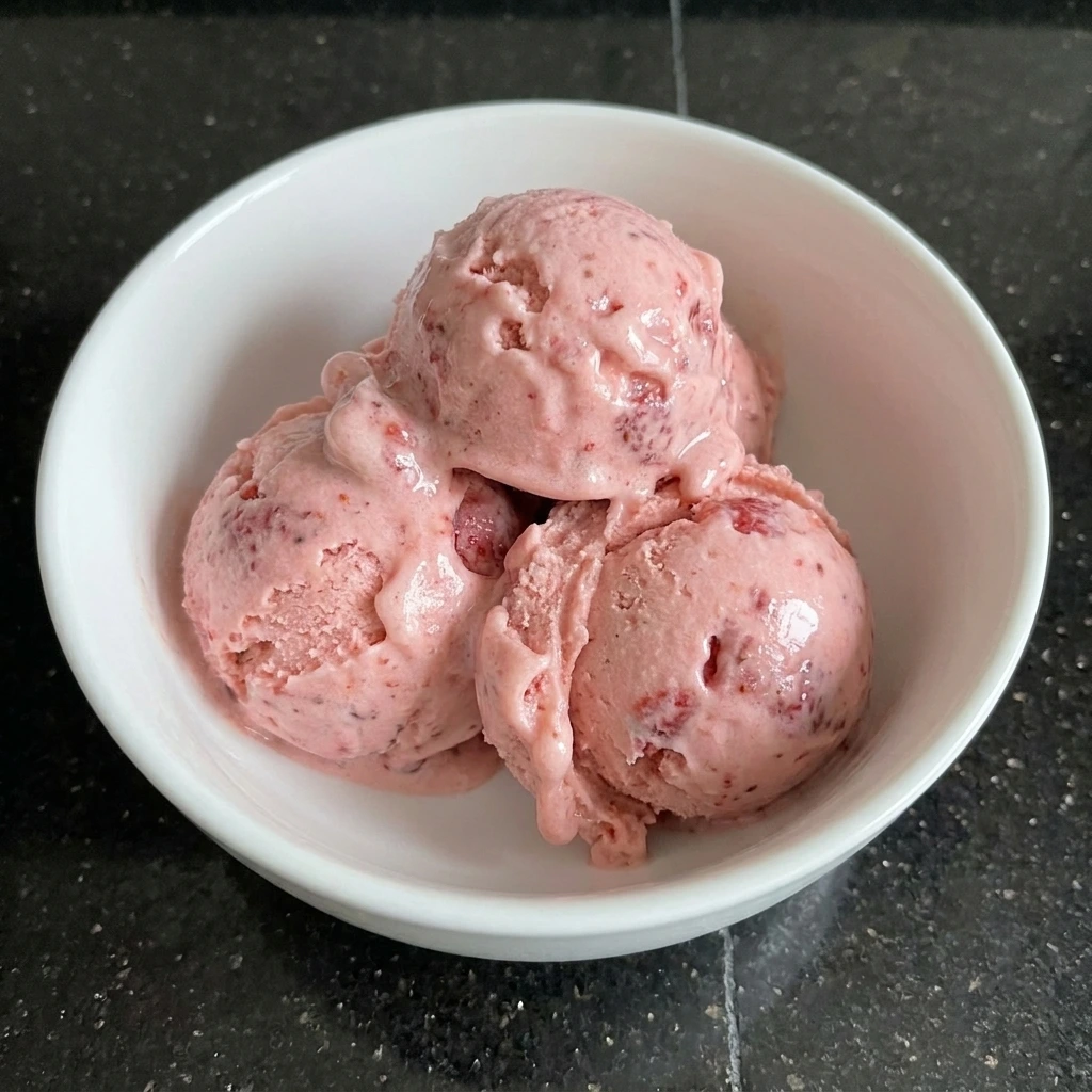 Served homemade strawberry ice cream in a bowl.