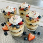 Vanilla pudding dessert cups layered with cookies and berries.