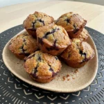 Bakery Style Huckleberry Muffins with golden tops and juicy berries