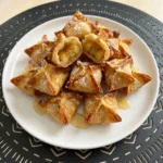 Crispy Banana Wonton Bites with powdered sugar and honey drizzle