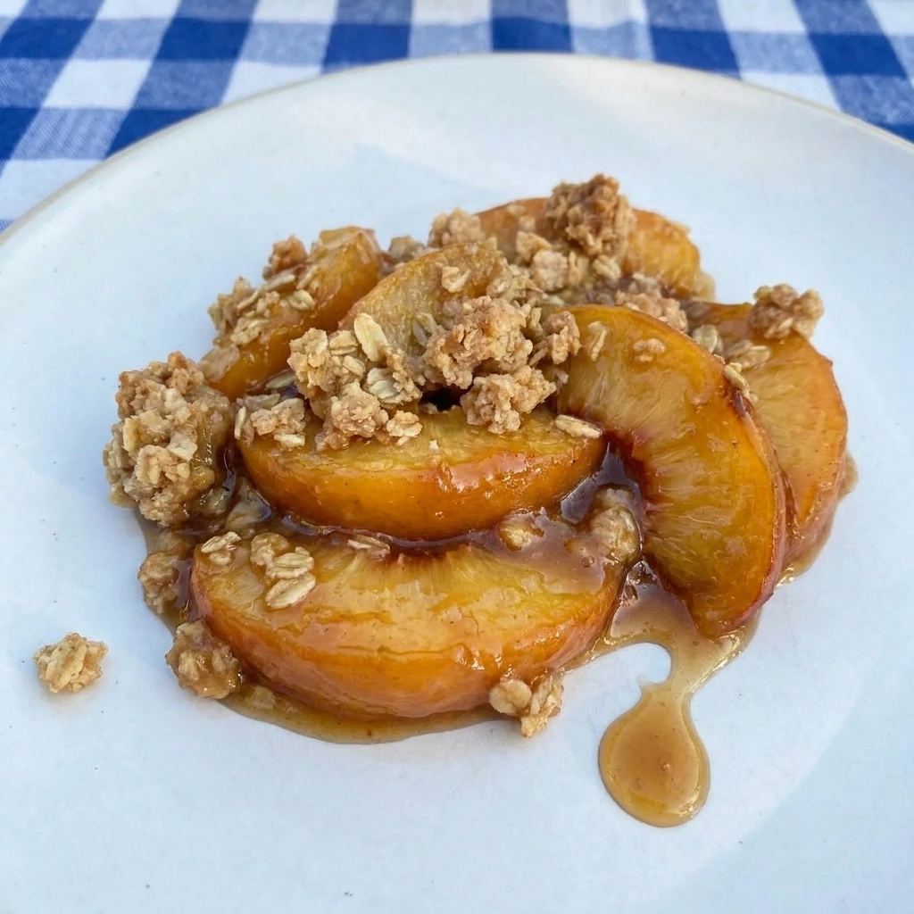 Single serving of Buttery Peach Crisp on a white plate