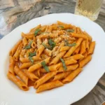 Creamy Tomato Pasta in a serving dish with basil and Parmesan