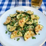 Garlic Parmesan Roasted Zucchini served on a white plate with golden cheese edges.