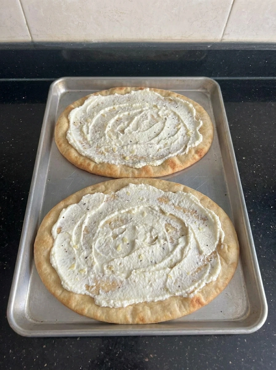 Ricotta garlic layer spread on flatbread crusts