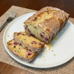 Raspberry Lemon Loaf Cake with lemon glaze and visible raspberry pieces