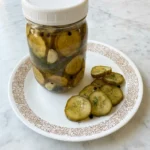 Jar of crisp refrigerator pickles with dill and garlic