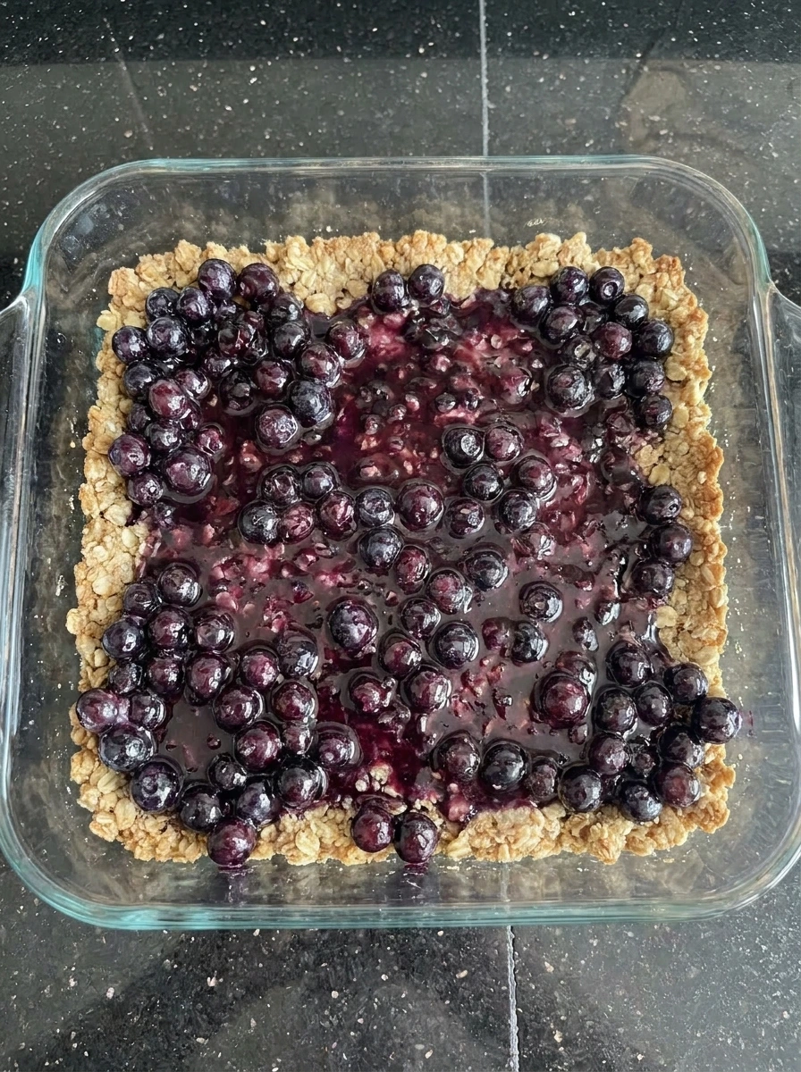 Huckleberry filling spread over crumble crust