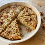 Fully baked Zucchini Oatmeal Bake with browned edges and walnut topping