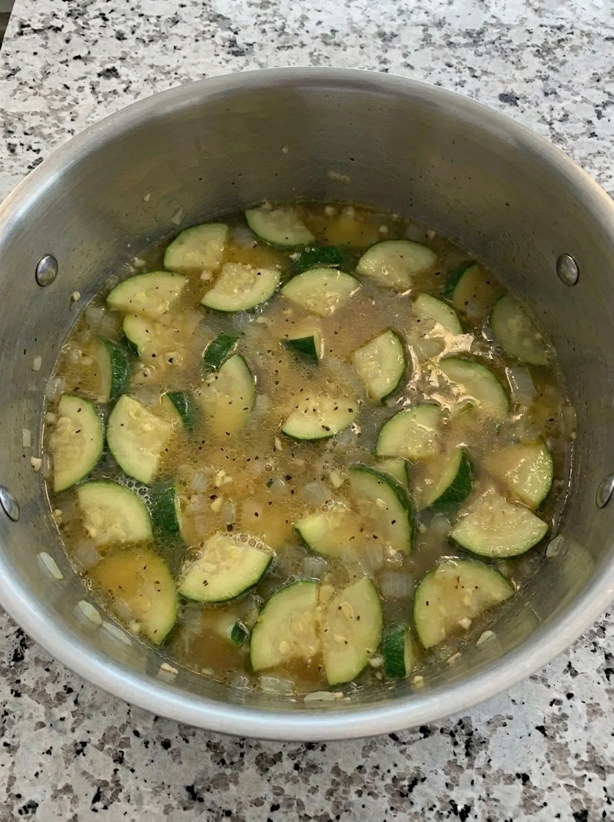 Zucchini simmering in broth for Parmesan soup