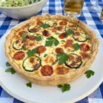 Finished Zucchini Tomato Quiche with golden crust and tomatoes