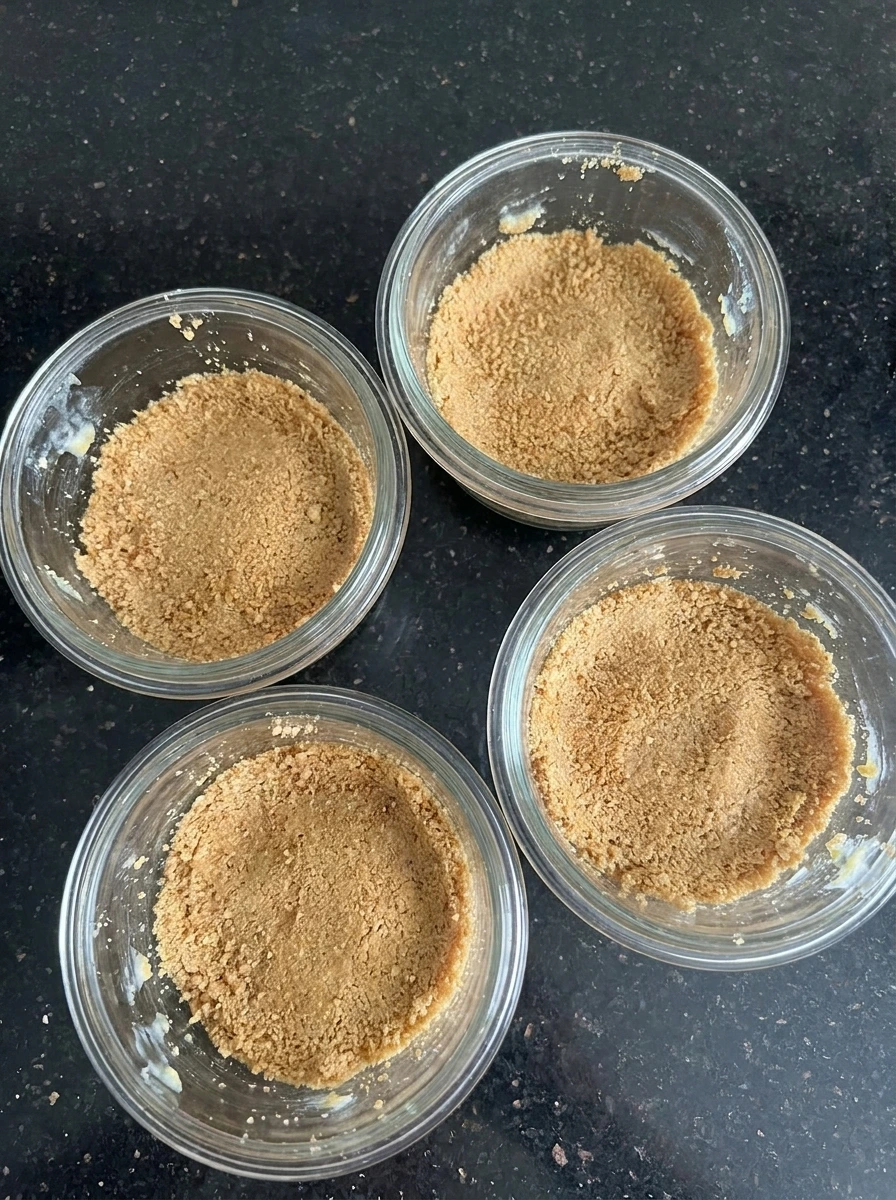 Graham crumb bases pressed into cups for Apple Crisp Cheesecake Cups