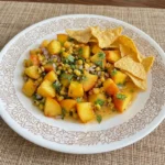 Fresh Peach Salsa with charred corn and cilantro served with tortilla chips