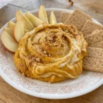 Pumpkin Cheesecake Dip in a serving dish with graham crumbs and apple slices