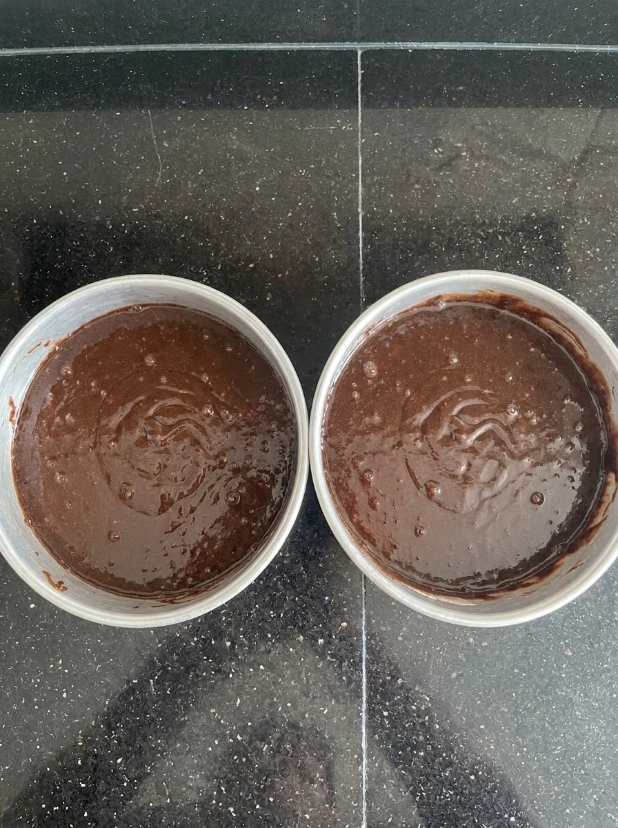 Chocolate batter divided into two cake pans