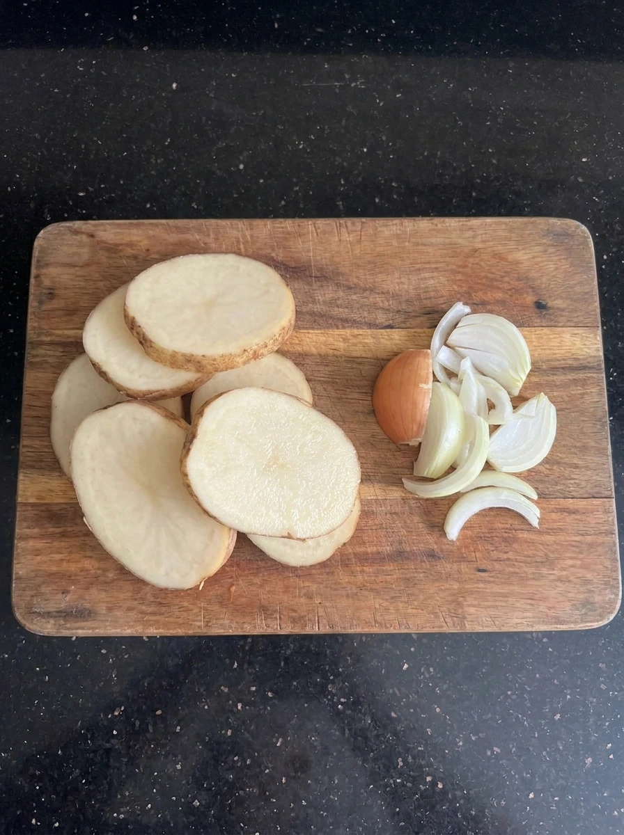 Sliced potatoes and onion for CrockPot Beefy Potato Taco Casserole
