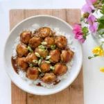 Crockpot Bourbon Chicken over white rice with glossy bourbon sauce
