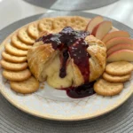 Halloween Bloody Baked Brie with raspberry sauce and flaky golden pastry