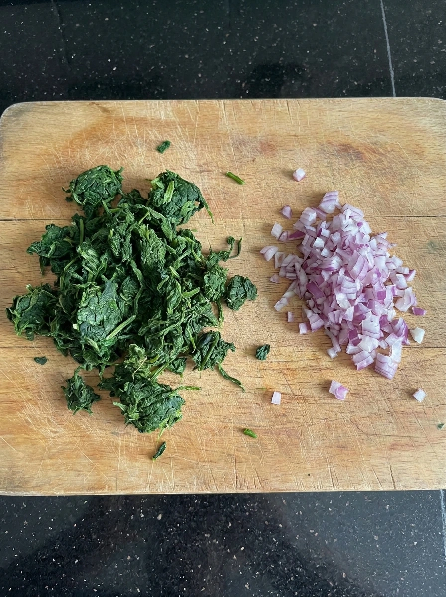 Squeezed spinach and chopped red onion for Halloween Spinach Dip