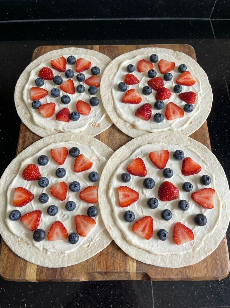 Tortillas topped with cheesecake filling and berries