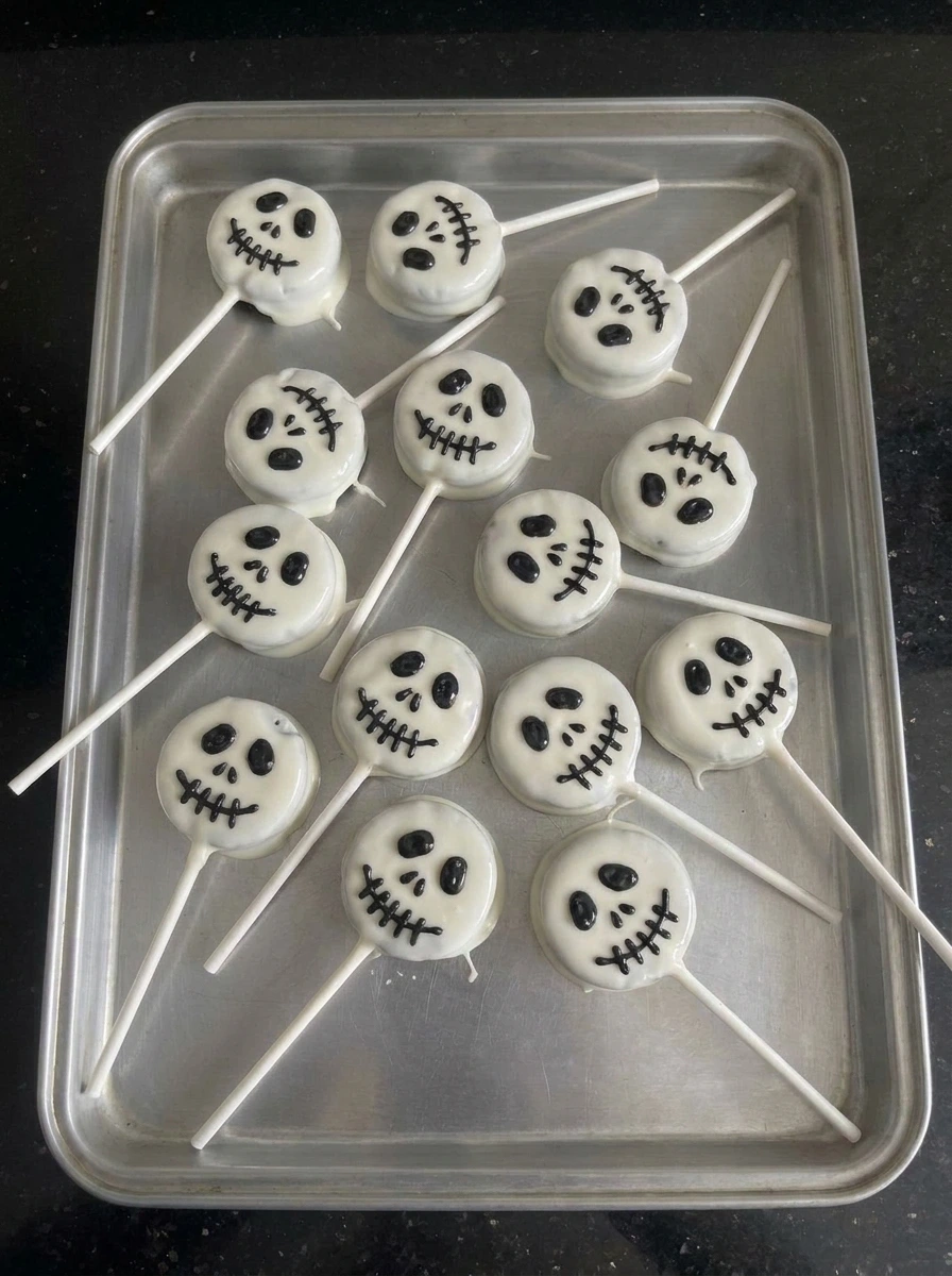 Black skeleton faces piped onto white Skeleton Cookie Pops