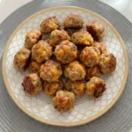 Golden Tomato and Green Chile Sausage Balls with cheddar on a white serving plate